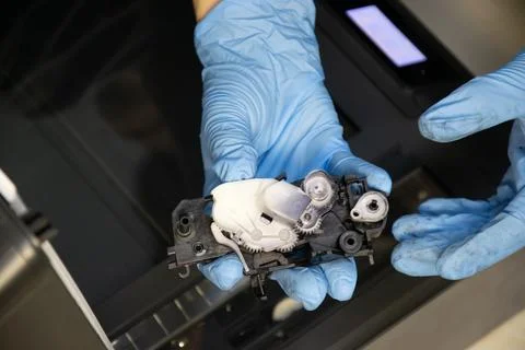 Top view of technician inspecting printer gear assembly. Stock Photos