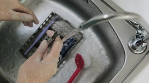 Top view of technician's hands wash dental tweezers under a distilled water Stock Footage 131683767