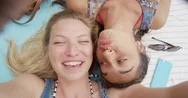 Top View Of Teenage Girl Friends Having Video Chat Lying On Back Sharing Travel Stock Footage