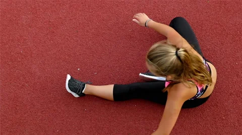 Top view of teenager girl athlete stretching before running on a stadium Stock Footage