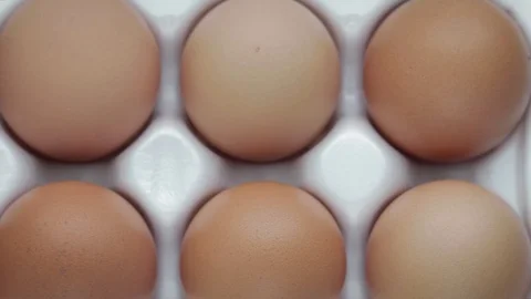 Top view of ten orange-shell eggs laid in a white tray 스톡 동영상 103352957