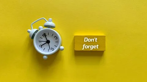 Top view of text - Do not forget with alarm clock and yellow background. Stock Photos