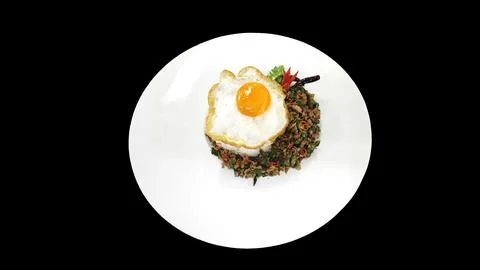 Top view of Thai basil pork rice with fried egg on black background. Fotos de archivo