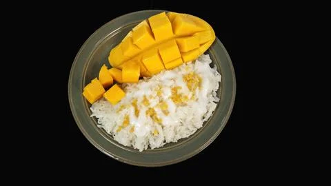 Top view of Thai dessert mango sticky rice isolated on black background. Stock Photos