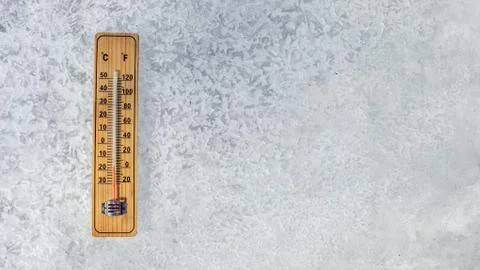 Top view on thermometer laying on layer of ice, showing temperature as low as Stock Photos