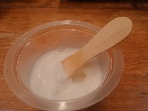 Top view of thick white cream in transparent plastic container Stock Photos