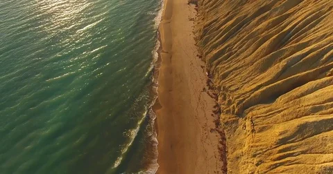 Top view of a thin path between the sandy mountain and the azure sea, the sun Stock Footage 79852803