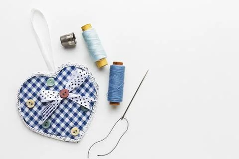 Top view thread with needles heart shaped fabric Stock Photos