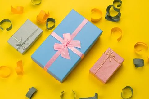 Top view three bright present boxes on a vibrant yellow background Stock Photos
