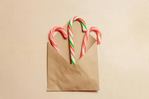 Top view three candy canes in brown envelope on brown color wood background Foto stock