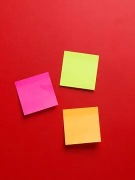 Top view of three colored reminder stickers in a red background, with space f 写真素材