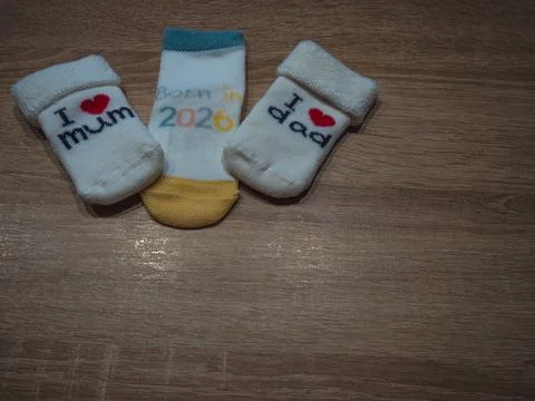 Top view of three cute white baby socks featuring lovely text messages: I Lov Fotos de archivo