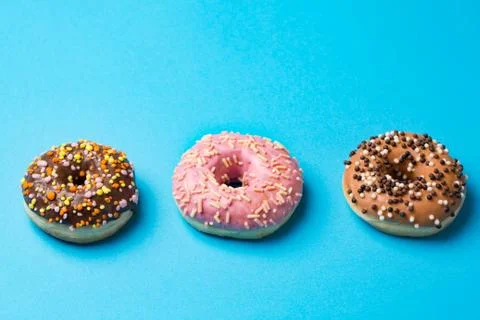 Top view of three donuts on blue background with copyspace Foto stock