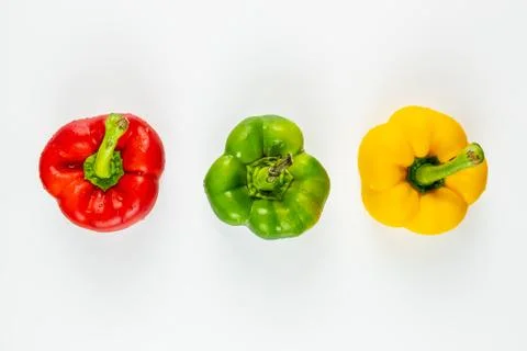 Top view of three fresh bright bell peppers on white background Stock Photos