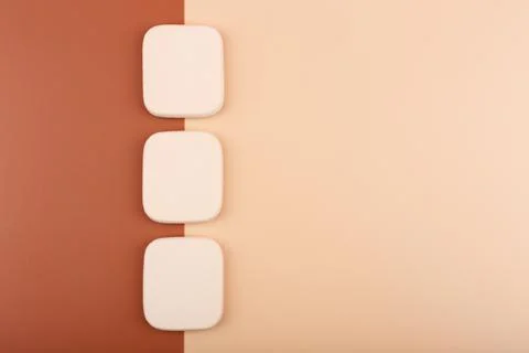 Top view of three make up sponges on beige and brown backgrounds. Concept of Stock Photos