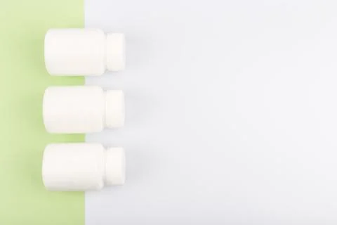 Top view of three medication bottles in a row on light green and white Stock Photos