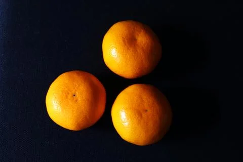 Top view of Three orange mandarin fruits against black background,Scientific  Stock Photos