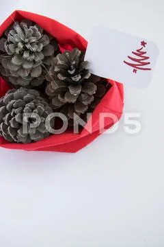Top view of three pine cones in red bag with seasonal greeting card, seasonal Stock Photos