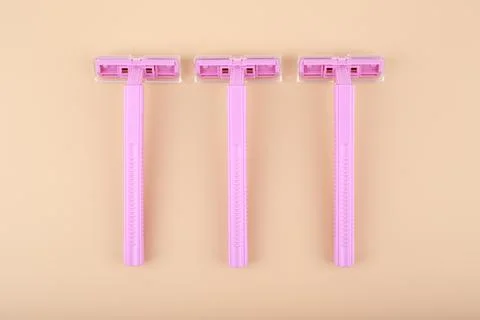 Top view of three plastic razors for shaving on beige background Stock Photos