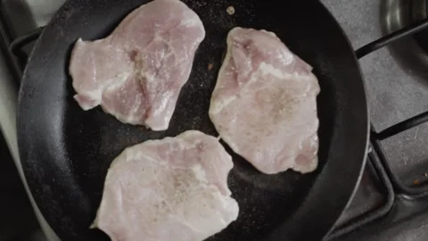 Top View Of Three Pork Loin Steaks Frying In A Pan Vídeos de archivo 334629621