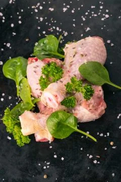 Top view on three raw chicken legs on black tray Stock Photos