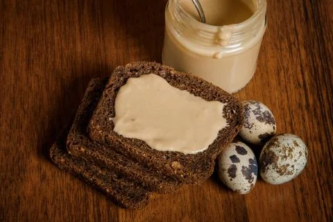 Top view on three rye bread slices with tahini butter and quail eggs Foto stock