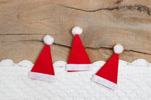 Top view of three santa hat with crochet strip on wooden background for chris Stock Photos