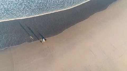 Top view of three surfers with their surfboards watching the sea from the s.. Stock Footage 270560196