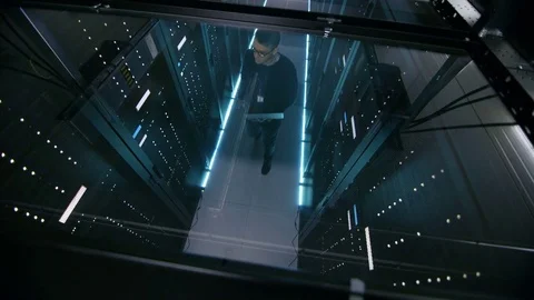 Top View Through the Glass of IT Engineer Working with Laptop in Data Center  Stock Footage 73891023