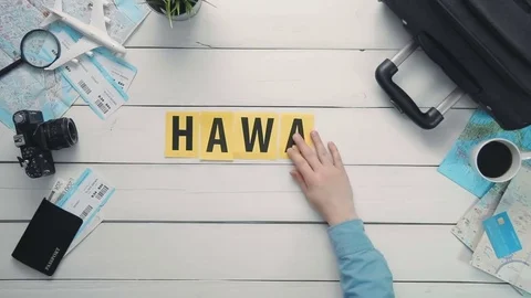 Top view time lapse hands laying on white desk word "HAWAII" decorated with Stock Footage 74957848