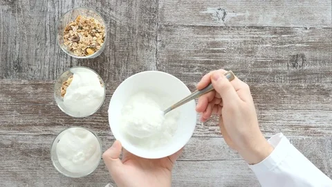 Top view timelapse of chef hands preparing muesli with natural yogurt Stock Footage 84104463
