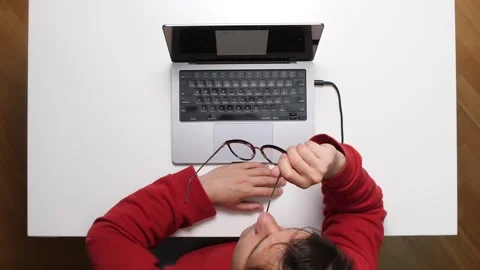 Top view Tired programmer removing glasses after working on laptop all day long Stock-Footage 311202203