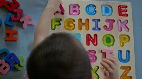 Top view of a toddler boy playing alphabet puzzle to learning English 動画素材 143575936