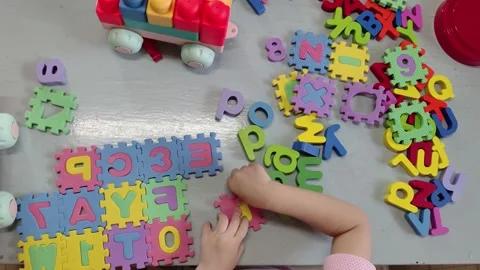 Top view of a toddler boy playing alphabet puzzle to learning English Vidéo 156433259