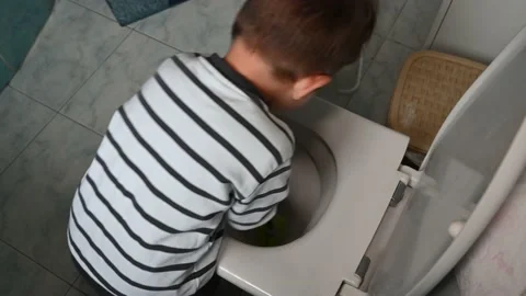Top view of toddler boy in striped clothes washes a toilet. Stock Footage 171381093
