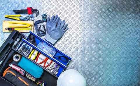 Top view of tools box and helmet on checkered plate background in workshop... Stock Photos