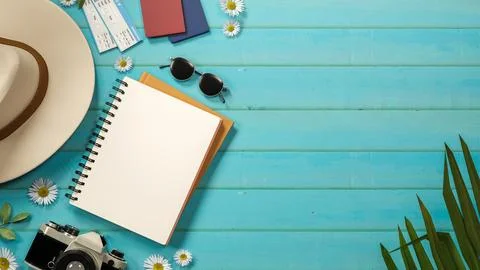 Top view of a tourist hat, camera on notebook and sunglasses with flower de.. Stock Illustration