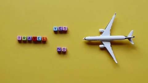 Top view of toy airplane close up, cube beads with words "Travel", "Yes", "No" Video stock 219382950