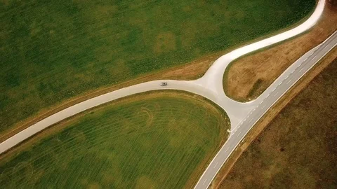 Top view tracking shot of car taking a turn on a road Stock Footage 99235861