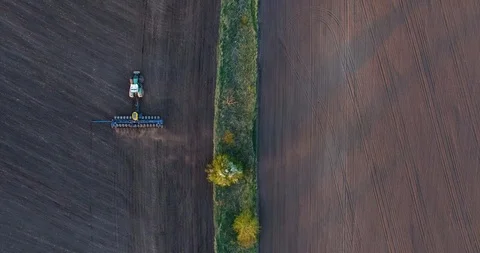Top view of a tractor planting wheat at sunset Video stock 88704385