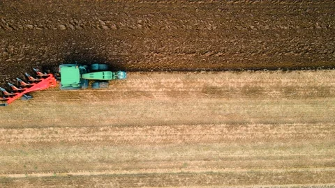 Top view of tractor plowing fields with rotary plow on large farm. Ploughing Stock Footage 209596585