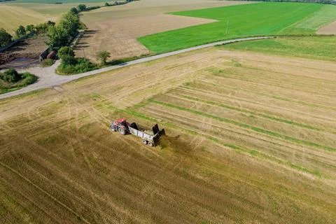 Top view of a tractor scattering manure from a trailer in the field. Work in the Stock Photos