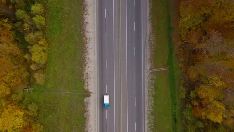 Top view of traffic on a highway surrounded by bright autumn forest. Stock Footage 138255714