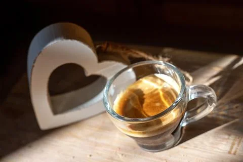 Top view to transparent coffee cup of italian espresso with wooden heart behind Stock Photos