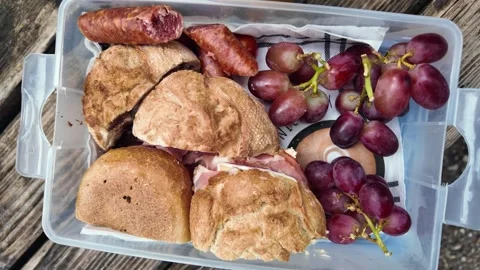 Top view of a transparent plastic container filled with buns, sausages, and Stock Footage 336088225