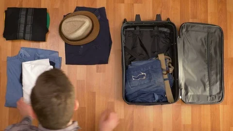 Top view travel concept of man organizing clothes into suitcase Stock Footage 74087280