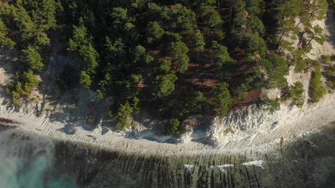 Top view on trees, white stony shore and clear surf waves of Black Sea 스톡 동영상 126243054