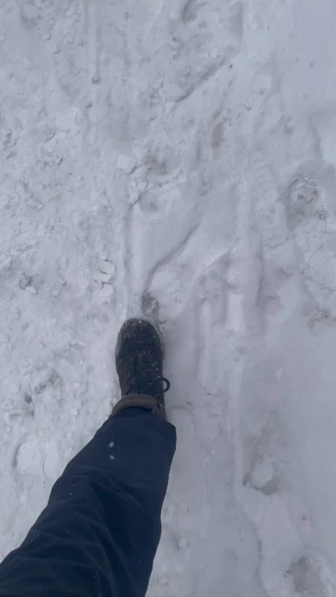 Top view of trekking boots walking on dirty trampled city snow. Feet step t.. Stock Footage 325306586