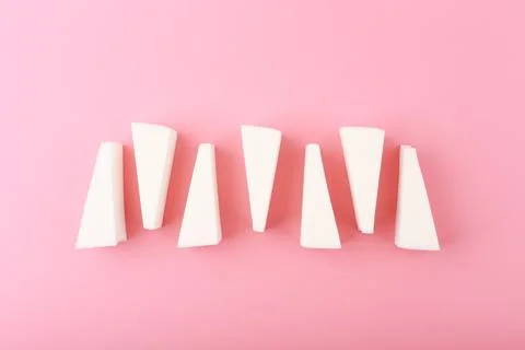 Top view of triangle shapes make up sponges on bright pink background Stock Photos