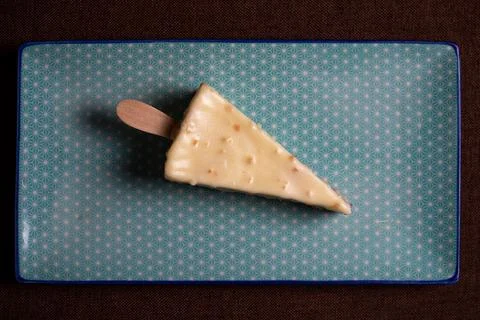Top view triangular dessert on a stick in white chocolate Stock Photos
